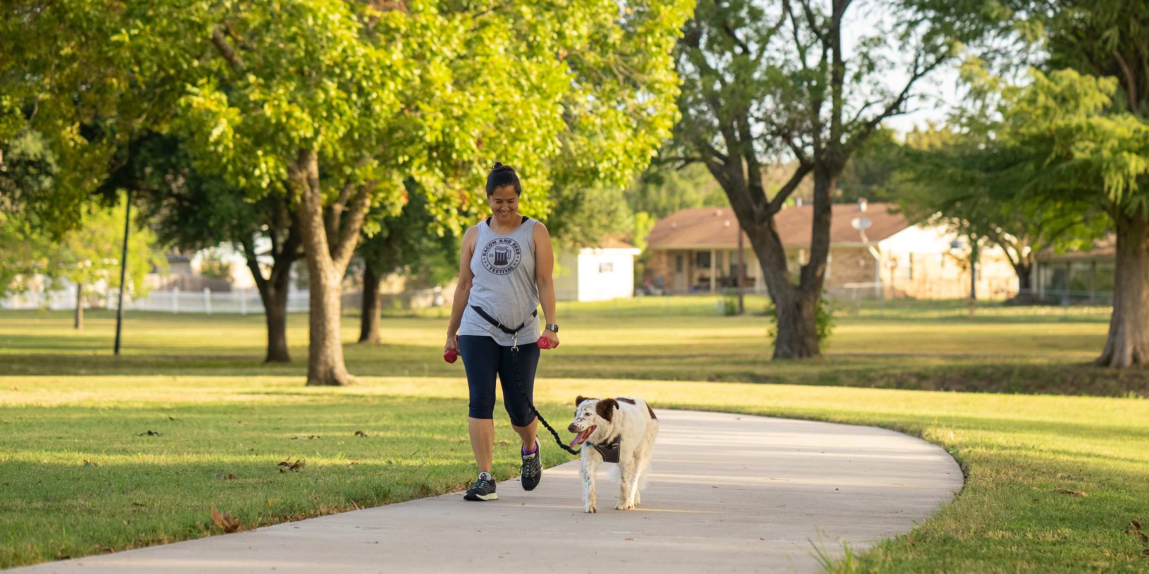 A woman walking her dog in a park